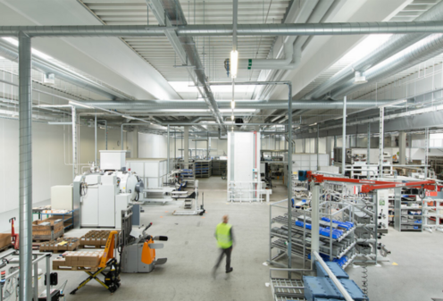 Industrie Person in einer Industrie- bzw. Produktionshalle.